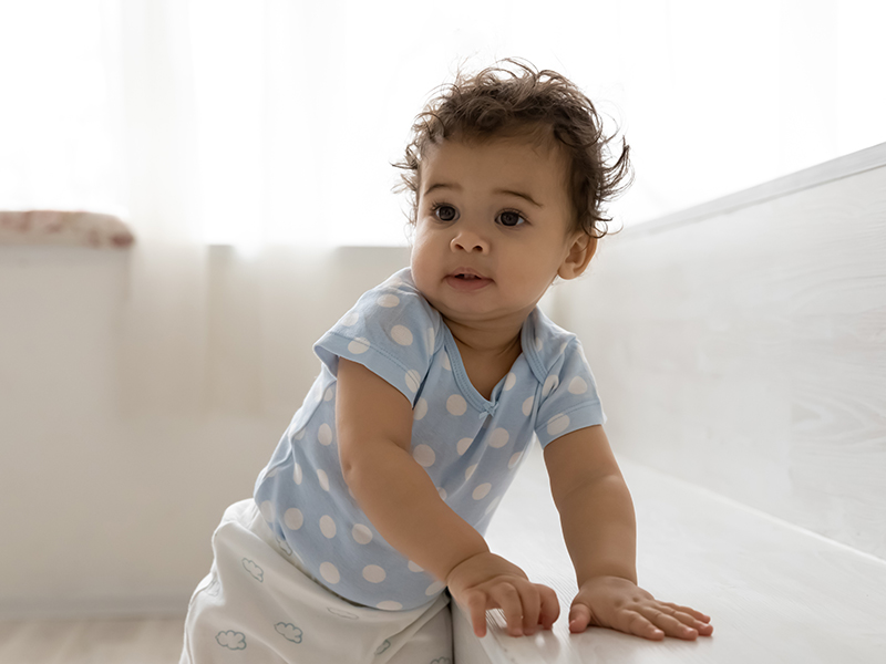 a baby leaning on a bench