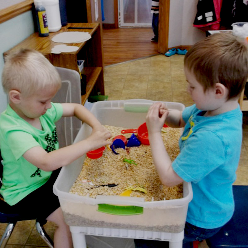 2 little boys playing in sand