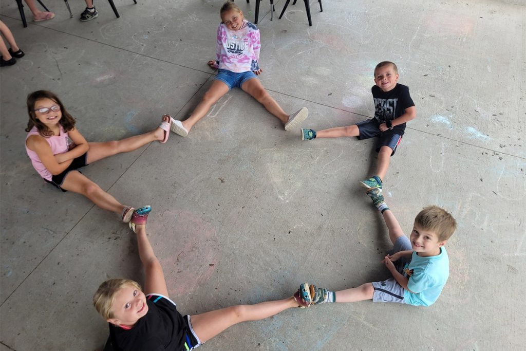 kids putting their feet together to make a star