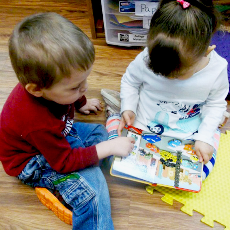 2 kids reading a book